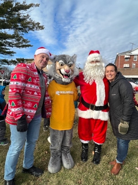 Mr Klamm Wesley the Wildcat Santa Claus and Mrs. Dowden Stand at Heyer's Park on the Square in Walworth for the Annual Tree Lighting Ceremony