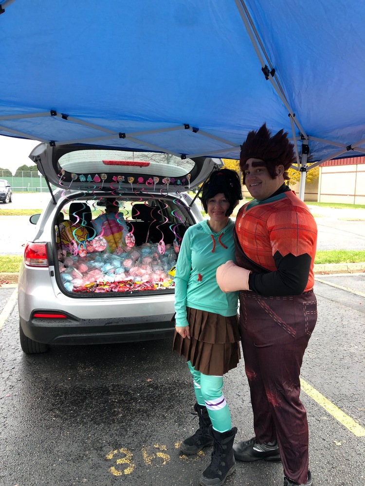 Two People Stand in Front of A Car Trunk Filled With Cotton Candy Dressed as Characters from Wreck It Ralph
