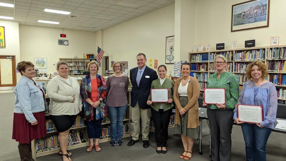 School Board, Administration, and WASB Business Honor Roll Recipients Stand for a Picture in the Library